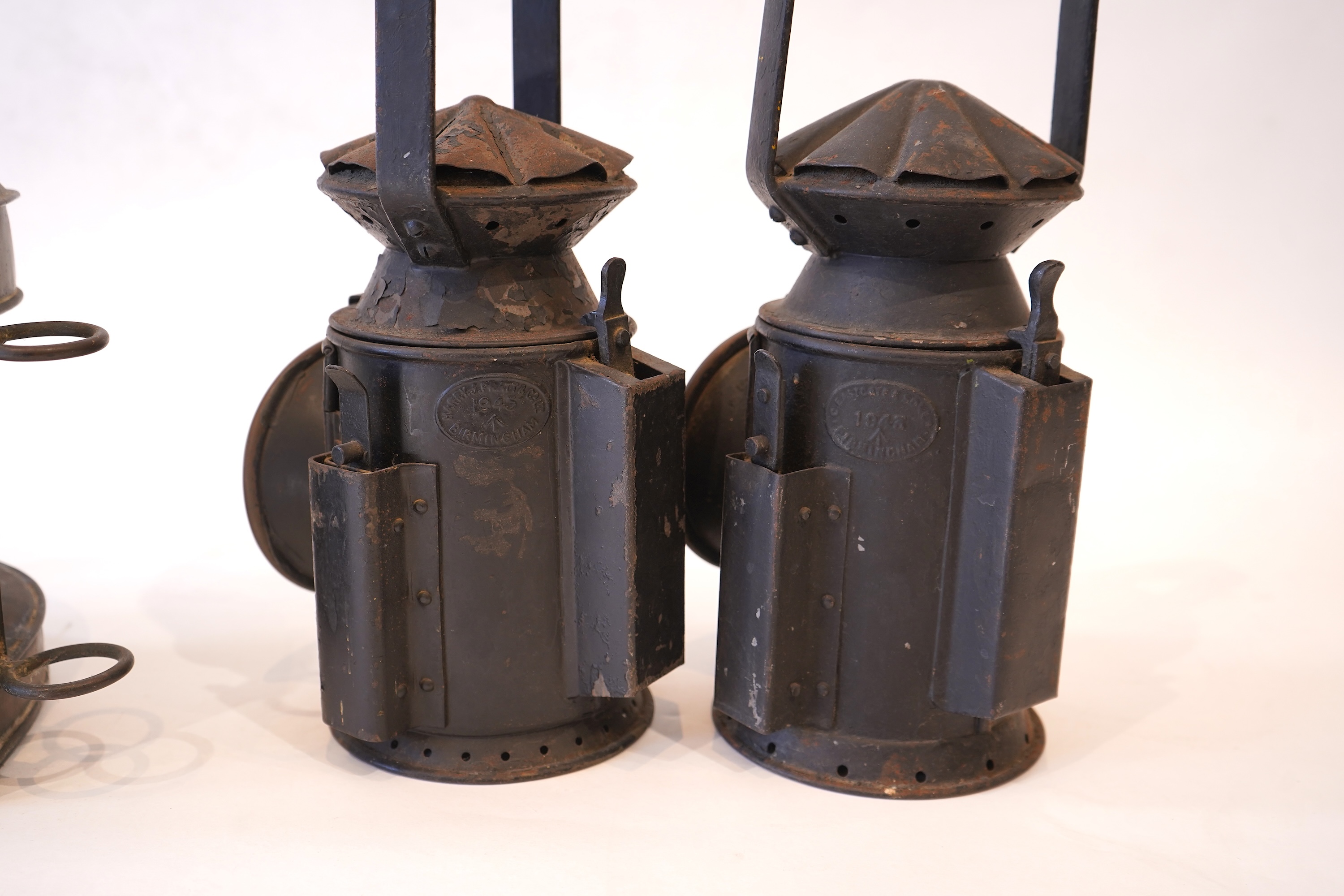 Two black painted railway hand lamps by Pratt & Co. Ltd. Birmingham, both dated 1945, both with burners and reflections, one intended for three colour aspect, with one glass missing, together with a brass ship’s bulkhead